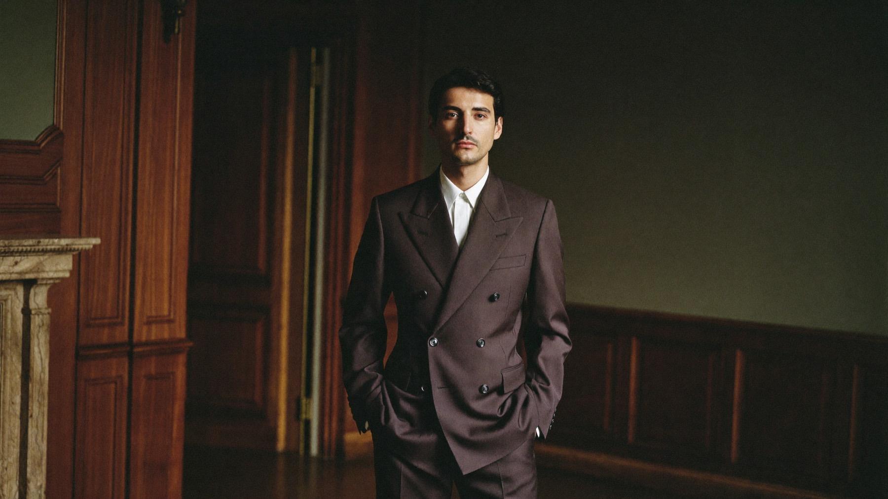Clients of The Bespoke Corner in tailored suits and traditional dress, in a walnut-panelled room